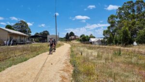 Korumburra station from the Leongatha end. Railway track and shed behind riders will eventually be removed as part of the precinct masterplan [2022]