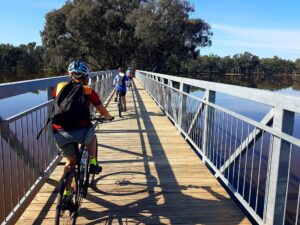 Riding across the long Mount Ida Creek bridge which is now part of a very full Lake Eppalock [2023 Garry Long]